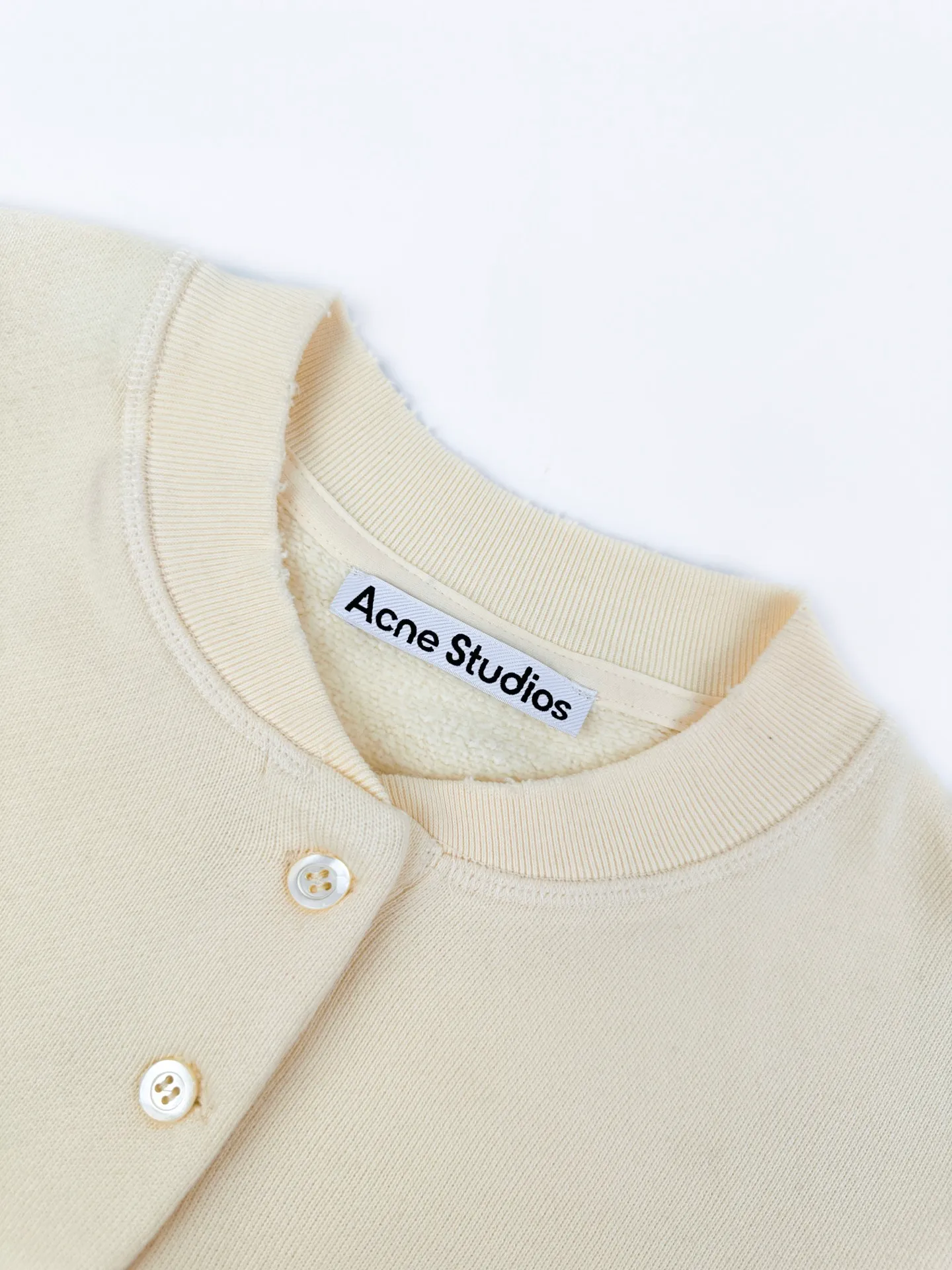 Acnee Studios logo-printed distressed sweatshirt. Customized polar-soled sweatshirt. Thick and soft. Warm velvet to the touch. Cream White ready-to-wear. The fabric surface spreads out with a warm matte texture. It gradually spreads the unique cool and luxurious charm of Scandinavia. The Henry collar half-buttoned placket outlines the soft collar line and elegantly modifies the outline of the neck. The body is engraved with mottled red brand letter prints. The Retro worn texture contains narrative details. Ribbing tightly locks the cuffs and hem, firmly shaping the body, loose and relaxed shoulder silhouette, eliminating redundant decorations. The collision between the soft background color and retro printing interprets the minimalist, relaxed and elegant style of Acne Studios. Process 1: Use an imported fully automatic flat screen printing machine to print the special printing slurry containing microcapsule foam particles on the surface of the fabric. After being heated in a high-temperature drying tunnel, the microcapsules in the slurry expand and swell when cooled and set. Process 2: Gradient distressed spray process. By spraying dyes of different colors on the surface of the fabric, the clothes can show rich color changes under different lights and increase the visual layering. Process 3: Positioned artificial fraying. Local friction and wear on the fabric through manual operations. The surface of the fabric will form a natural damage effect. It is time-consuming and labor-intensive. The daily output is low. Process 4: The fabrics have been fermented and washed. The hand feel and texture are better. It is not easy to deform, not easy to shrink, not easy to fade, and maintains long-term beauty. Accessories: Customized 1:1 Acne buttons Customized 1:1 Acne trademark Version: Loose version Size: S M L XL Style number: CC